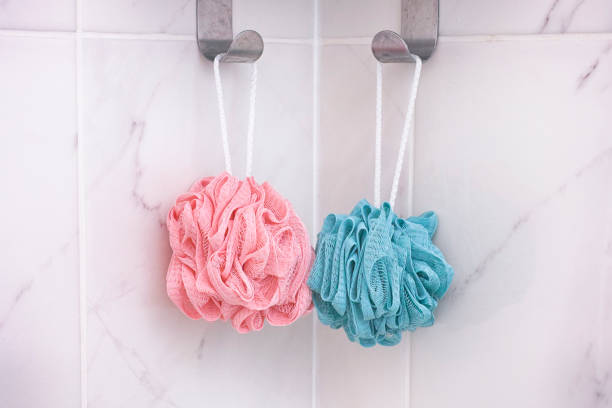 scrubber doccia rosa e blu - luffa prodotto per ligiene personale foto e immagini stock