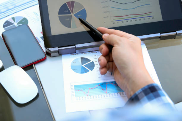 istock Business man working and analyzing financial figures on a graphs using laptop and tablet 1250268545