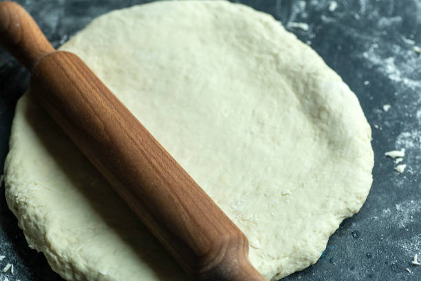 istock Dough pizza background. Cooking pizza dough or bread on the kitchen table. Food background 1250271151
