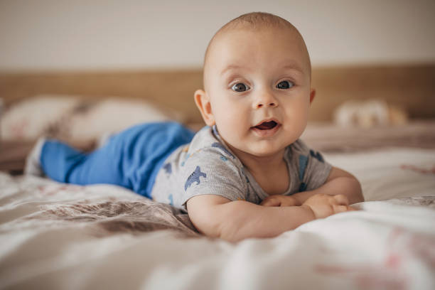 istock Cute baby boy lying on bed and smiling 1250271547