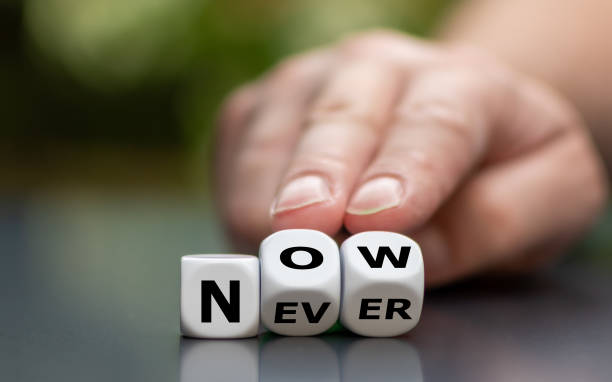 istock Now or never? Hand turns dice and changes the word 