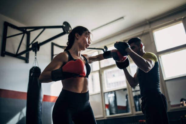 istock Young fit woman kickboxer sparring with her coach 1250272229