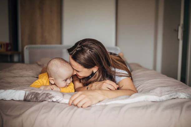 istock Happy mom lying with her baby son on bed 1250272817