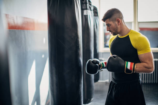 istock Man kickboxer punching a punching bag 1250274298