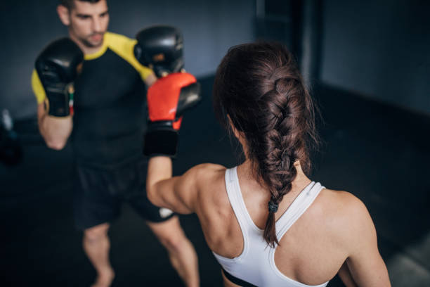 istock Female kickboxer sparring with her coach 1250274855