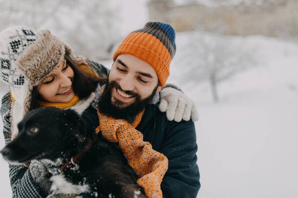 istock Couple in the snow play with dog 1250274979
