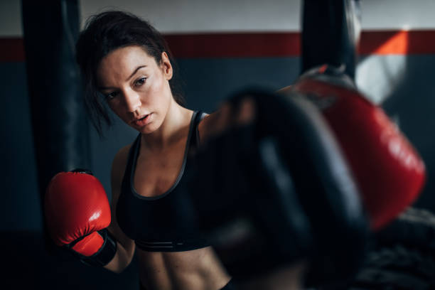 istock Beautiful woman kickboxer sparring with her coach 1250275196