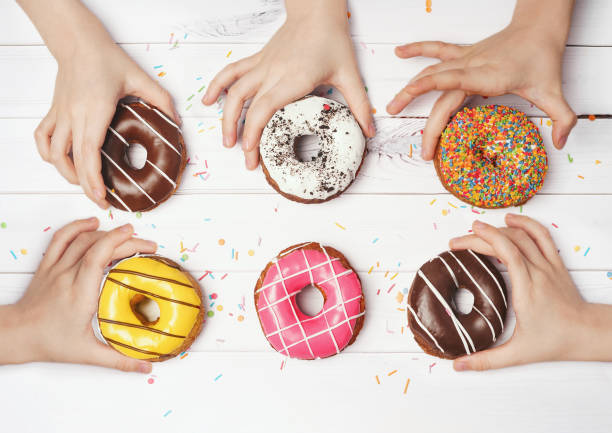 istock Multiracial hands are with taking colorful donuts. 1250275918
