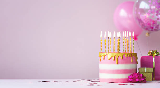 istock Pink birthday cake with golden candles 1250275944