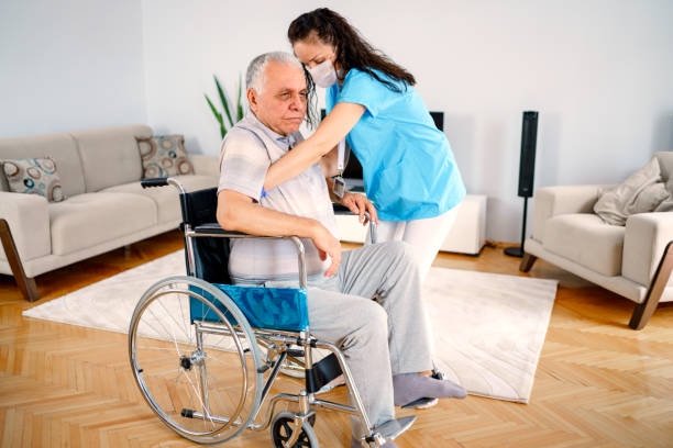istock Physical disability. Nice sad aged man holding a caregivers hand and trying to get up while having a physical disability 1250277583