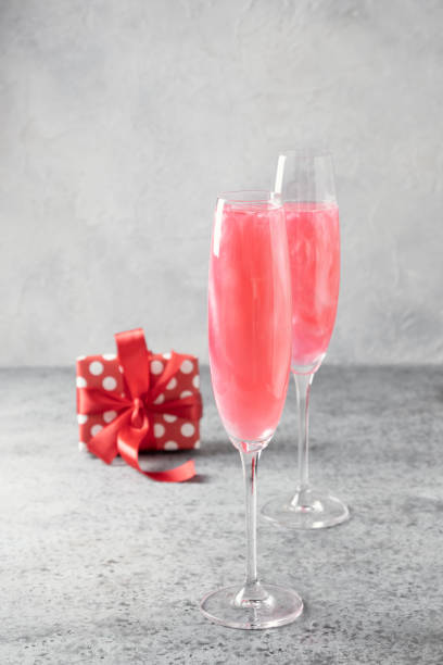 istock Shimmer edible glitter sparkling wine in two glasses with gift on grey. 1250277586