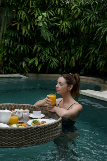 Woman enjoying floating breakfast, beautiful beginning of summer day