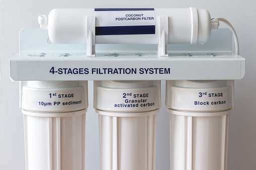 Four stages water filtration system for the home with: coconut postcarbon filter, granular activated and block carbon filters. Reverse osmosis system. Closeup view