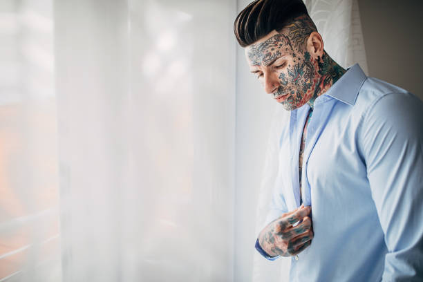 One man, modern tattooed man, standing in his apartment.