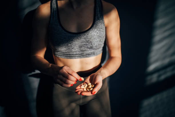 ジムでトレーニング後に健康的なスナックを食べるフィット女性 - sport food exercising eating ストックフォトと画像