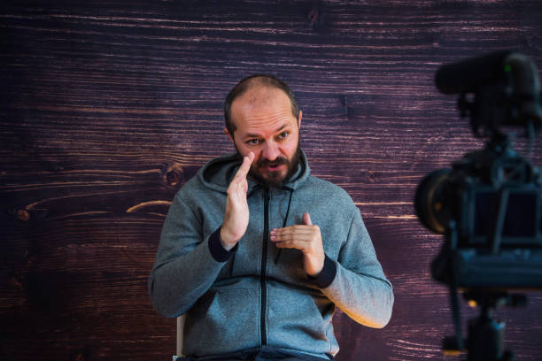 istock Man in studio vlogging in front of camera 1250286765