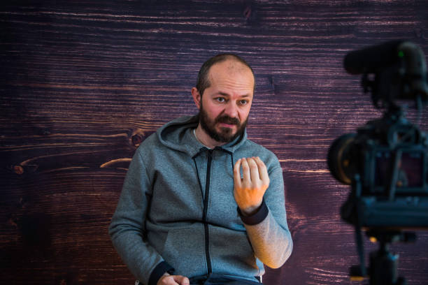 istock Man in studio vlogging in front of camera 1250286788