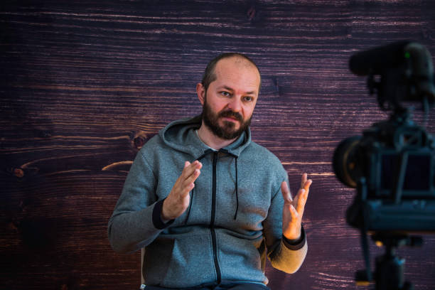istock Man in studio vlogging in front of camera 1250286811