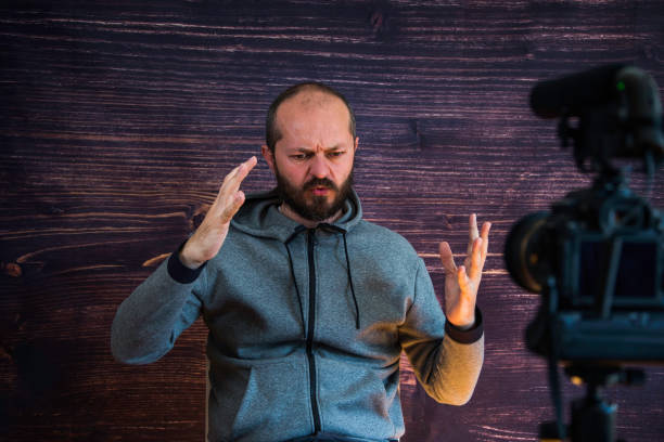 istock Man in studio vlogging in front of camera 1250286842