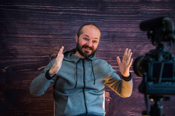 istock Man in studio vlogging in front of camera 1250286856