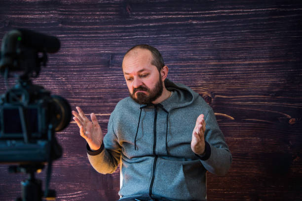 istock Man in studio vlogging in front of camera 1250286864