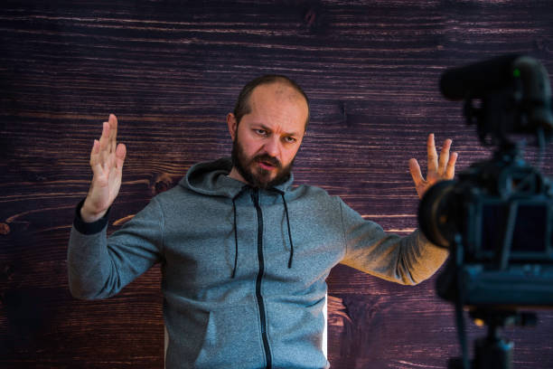 istock Man in studio vlogging in front of camera 1250286866
