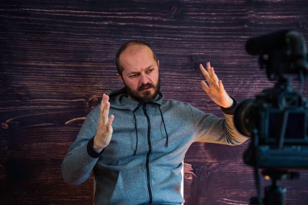 istock Man in studio vlogging in front of camera 1250286885