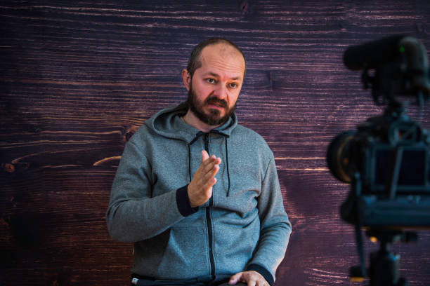 istock Man in studio vlogging in front of camera 1250286896