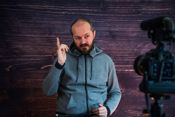 istock Man in studio vlogging in front of camera 1250286915