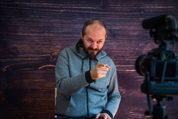 istock Man in studio vlogging in front of camera 1250286935