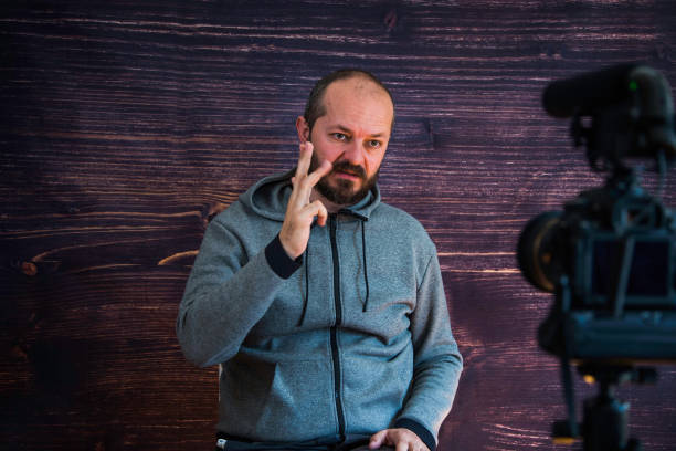 istock Man in studio vlogging in front of camera 1250286943