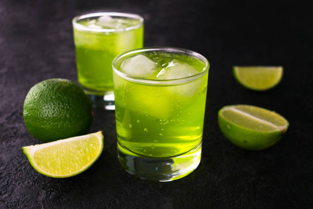 黒い背景にライムと氷を入った緑の飲み物。 - tarragon herb freshness green ストックフォトと画像