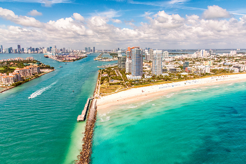 The shipping channel leading to the Port of Miami adjacent to South Beach, Miami with the city's skyline in the distance from an altitude of about 800 feet over the Atlantic Ocean.
