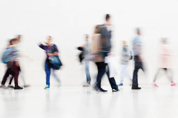 istock Group of People Walking on White Hallway, Motion Blur Effect 1250297311