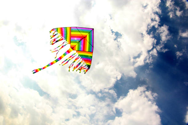 view of multicolored kite flying in the sky with clouds