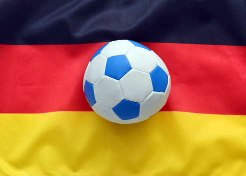 Closeup of a toy soccer ball on the German flag.
