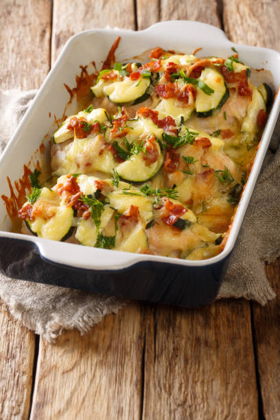istock Baked chicken breast with zucchini, bacon and cheese close-up in a baking dish. vertical 1250299865