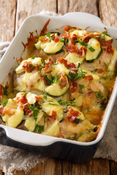 istock Creamy chicken zucchini casserole with bacon close-up in a baking dish. vertical 1250299889