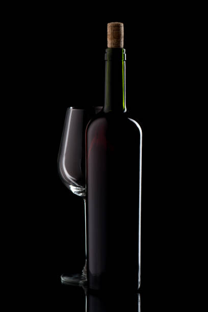 istock Wine bottle with cork and empty glass on black isolated background 1250299969