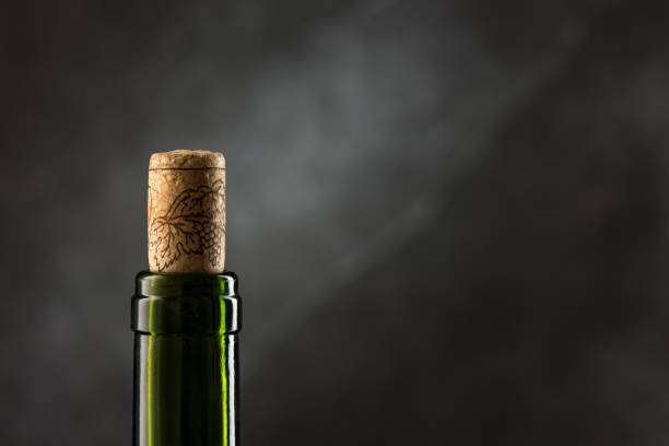 istock Green wine bottle with cork on dark background, close-up view 1250299979