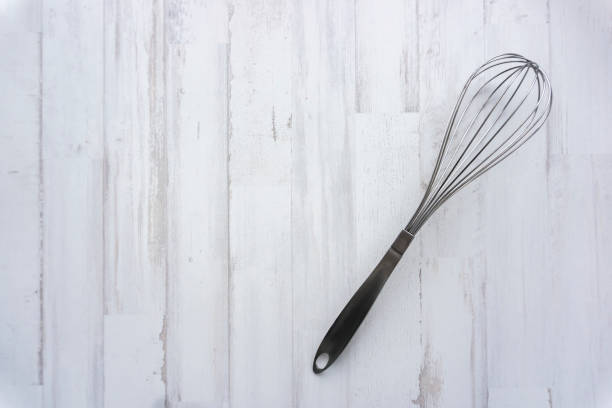 istock metal whisk on wooden background 1250301243