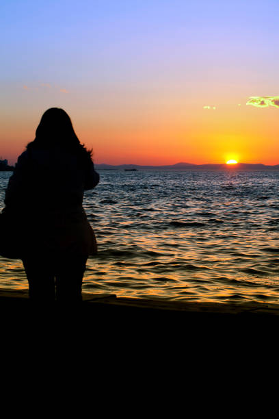 istock People Silhouette and the Sea in Sunset 1250302380