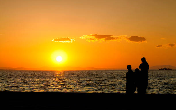 istock People Silhouette and the Sea in Sunset 1250302385