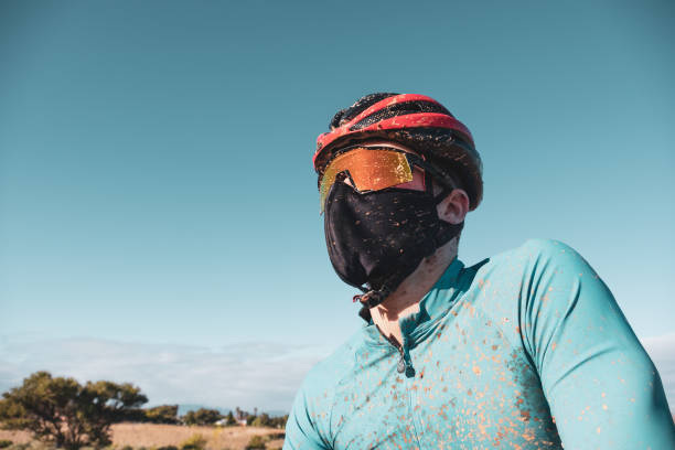 천 얼굴 마스크를 쓰고 있는 산악 자전거 타는 사람의 초상화 스톡 사진