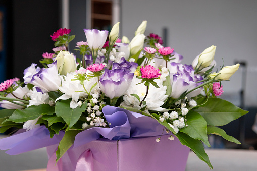 Beautiful luxury bouquets of eustoma and mix flowers in the box, close-up. Bouquet for wedding day or womens day. Concepts of flower shop and professional florist
