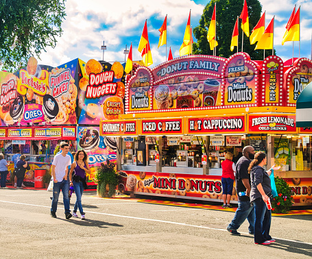 West Springfield, Massachusetts, USA-September 18, 2014- Smiling fairgoers stroll past the colorful food vendors at the annual Eastern States Exposition.