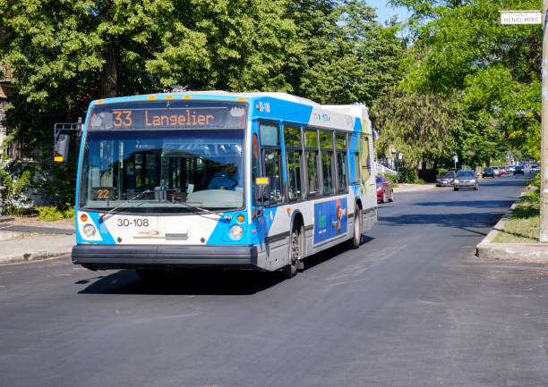 Montreal STM city bus on city street Montreal, Canada. June 15, 2020.  A Montreal STM city bus, number 33 Langelier, driving down a street on sunny summer day stm photos stock pictures, royalty-free photos & images