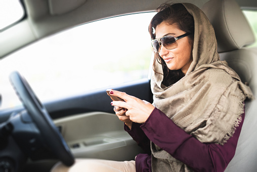 arab woman with phone in the car