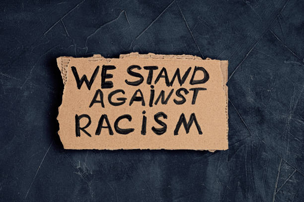 We stand against racism text on cardboard over dark background We stand against racism text on cardboard over dark background strike protest action photos stock pictures, royalty-free photos & images