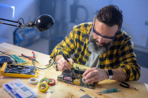 istock Caucasian man soldering a motherboard in his garage workshop 1250312726